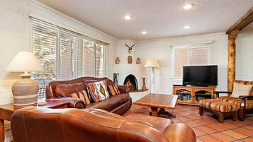 Relax in this stylish living room with a leather sofa, flat-screen TV, and fireplace.