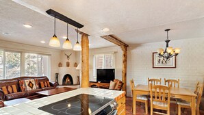 Una cocina con isla central, sillas de madera y una mesa de comedor.