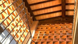 A staircase with a patterned brick wall and metal railings. - IL PIANETTO (Pieve Fosciana)