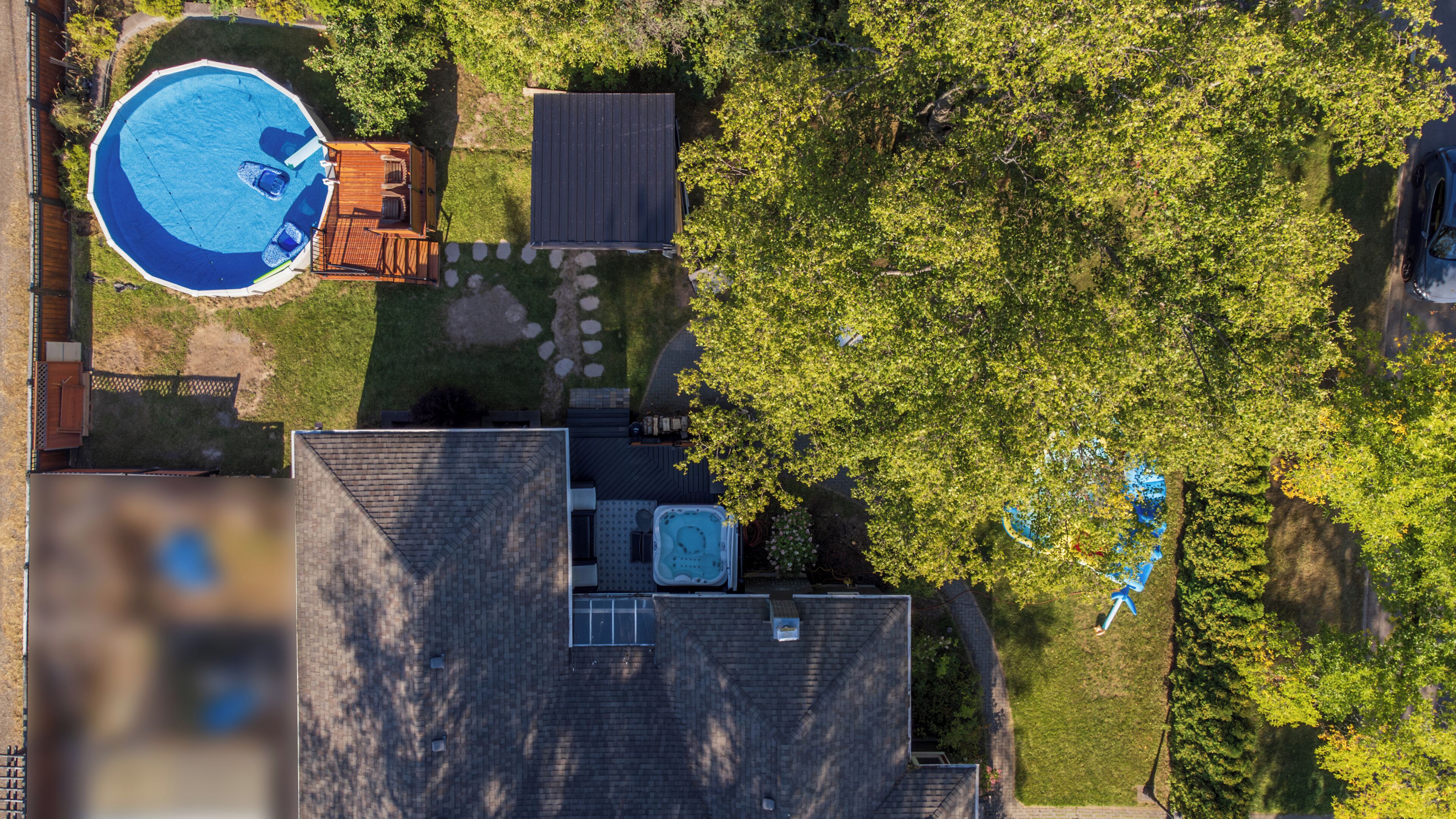 Vue aérienne d’une propriété résidentielle dotée d’une piscine, d’un jacuzzi et d’un jardin clos.