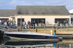 Un barco amarrado en un puerto deportivo, con un edificio al fondo.