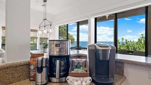 A kitchen with a coffee maker, a coffee pot, a coffee grinder, and a coffee pod dispenser. - Beachfront🌊3 KING suites & bunk room🛏️Pet Friendly🐾 (Captiva)