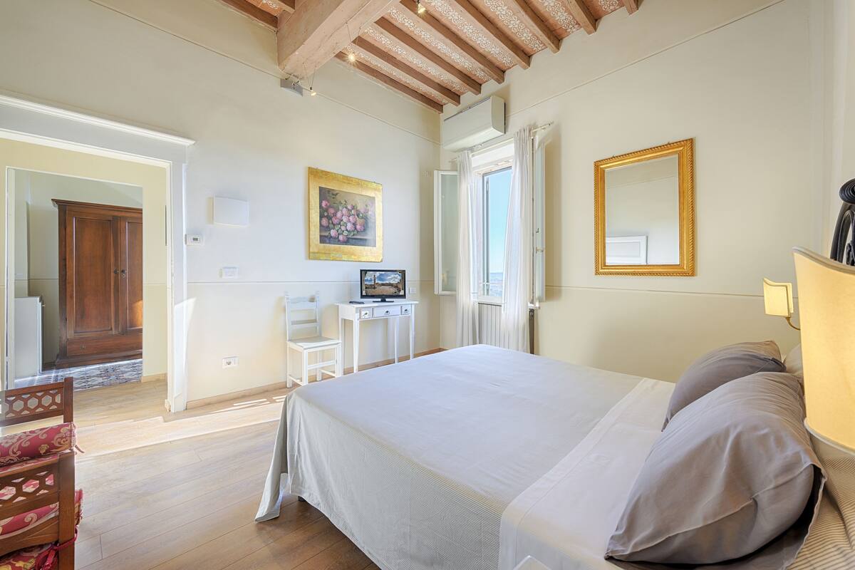 Une chambre à coucher avec un lit, un bureau, une chaise et une fenêtre.