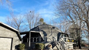 A house with a unique dome-shaped roof, a garage, and a small outdoor staircase leading to a deck. - Geo Dome - Unique Urban Getaway – one of a kind! (Springfield)