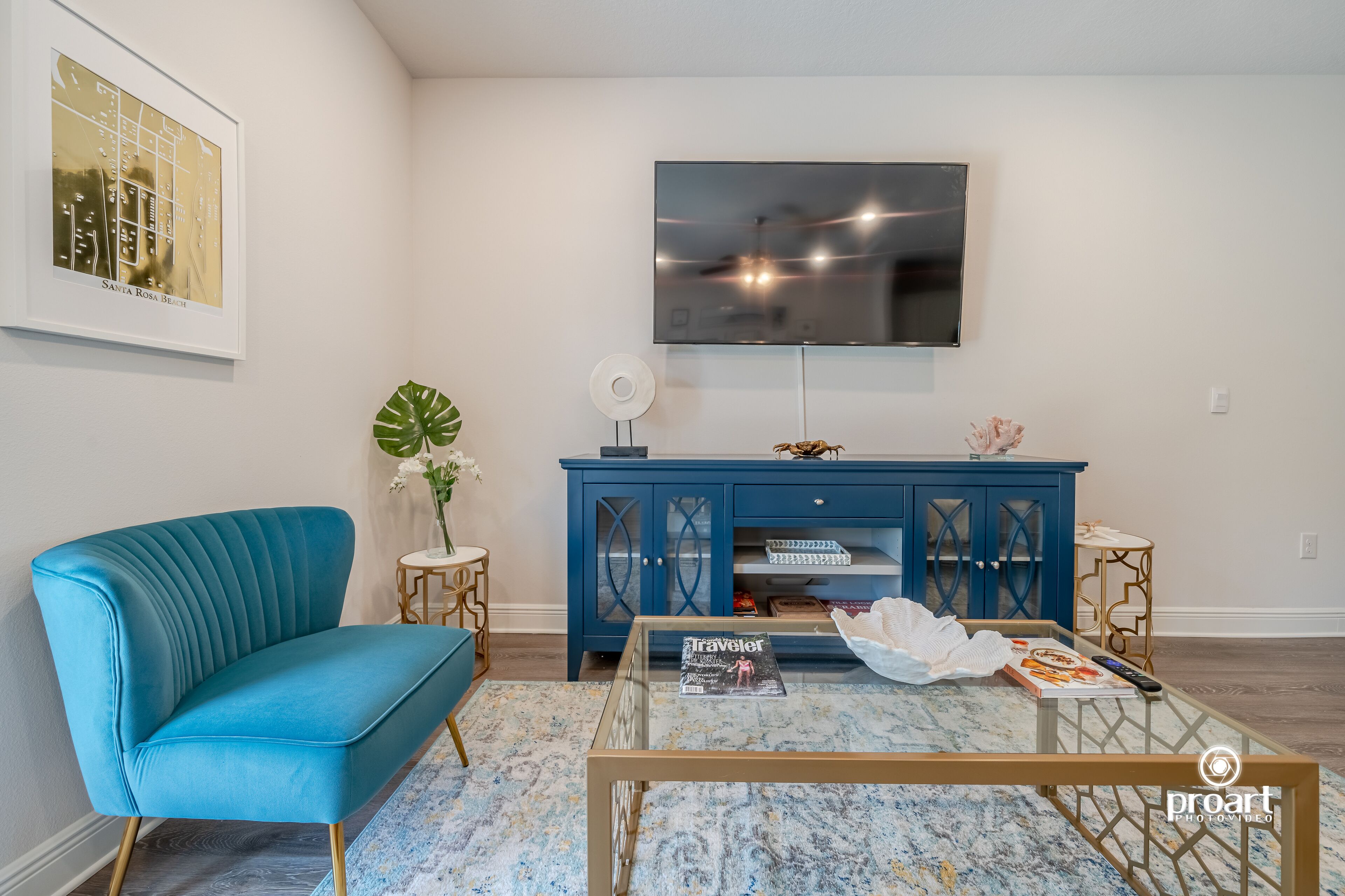 Un salon avec un canapé bleu, une table basse, un téléviseur et un meuble bleu.