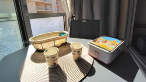 Une table avec un set de table en fibres tressées, deux tasses, un petit bol et une boîte à l’étui coloré.