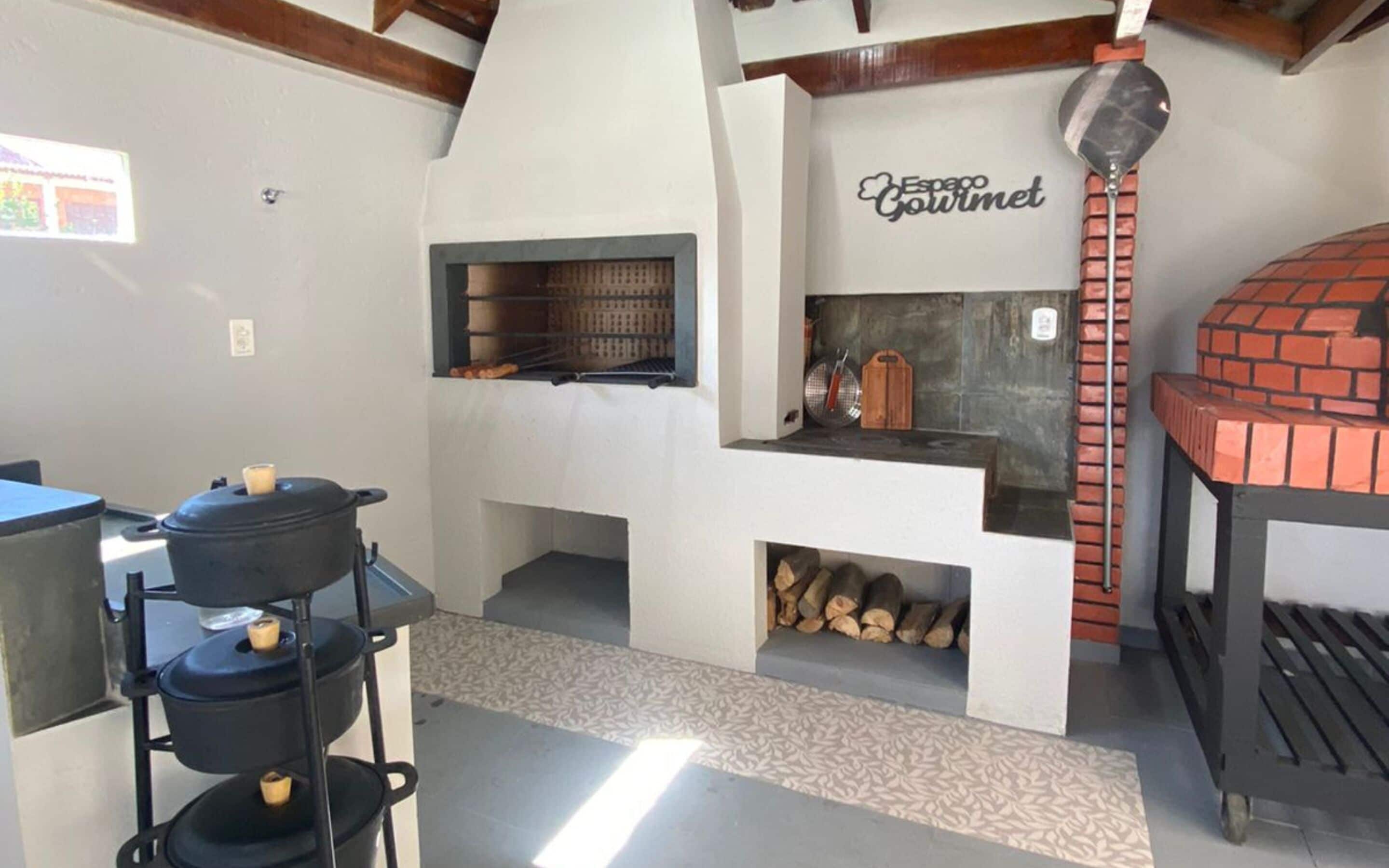 A kitchen with a pizza oven, a grill, and a sign that says "Espacio Gourmet".
