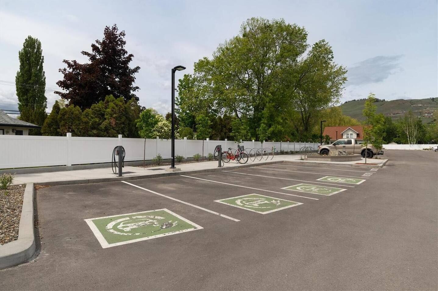 A parking lot with designated bike lanes and electric vehicle charging stations.
