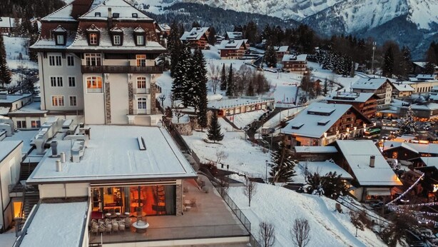 Ein Resort mit Swimmingpool, verschneiter Umgebung und Bergblick.