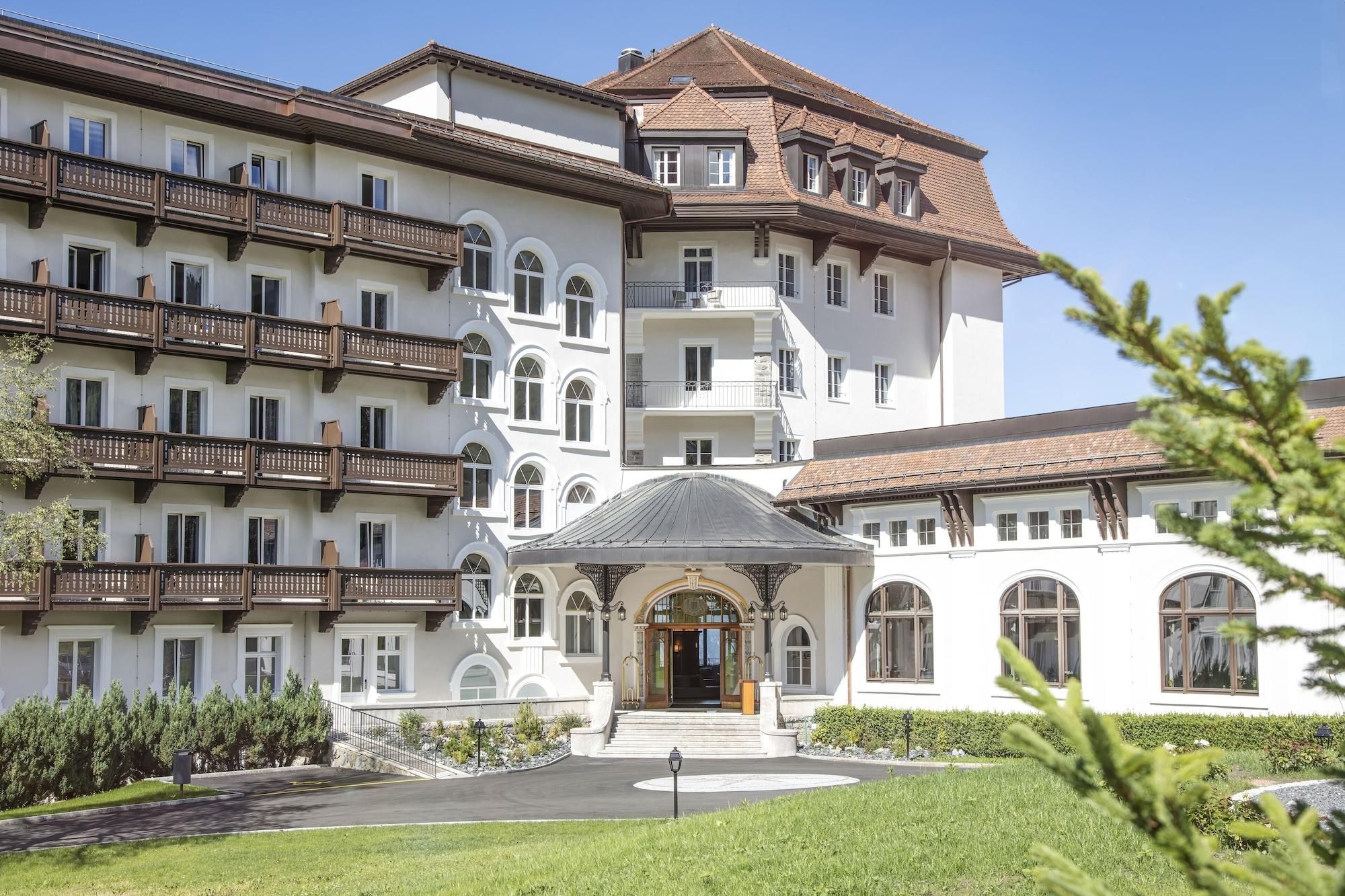 A multi-story hotel with a central courtyard, balconies, and a traditional architectural style.