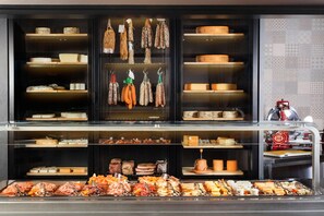 Un comptoir de charcuterie où sont présentées, dans des vitrines réfrigérées, différentes sortes de viandes, de fromages et de charcuteries.