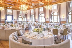 A banquet hall with round tables set for dining, large windows, and chandeliers. - Villars Palace (Ollon)