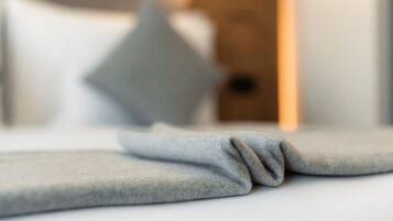 Ein verschwommenes Hotelzimmer mit einem Bett und einem Kissen.