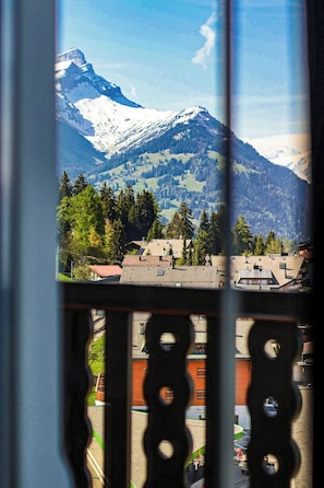 A mountain view from a window with a balcony railing. - Villars Palace (Ollon)