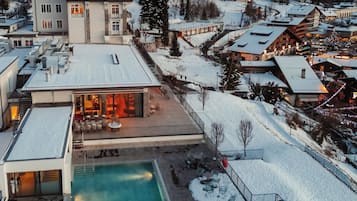 Ein Resort mit Swimmingpool, verschneiter Umgebung und Bergblick.