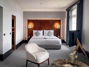 Une chambre d’hôtel moderne dotée d’un grand lit, d’un coin salon et d’une télévision.