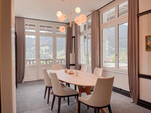 A dining room with a large table, six chairs, and a chandelier. - Villars Palace (Ollon)