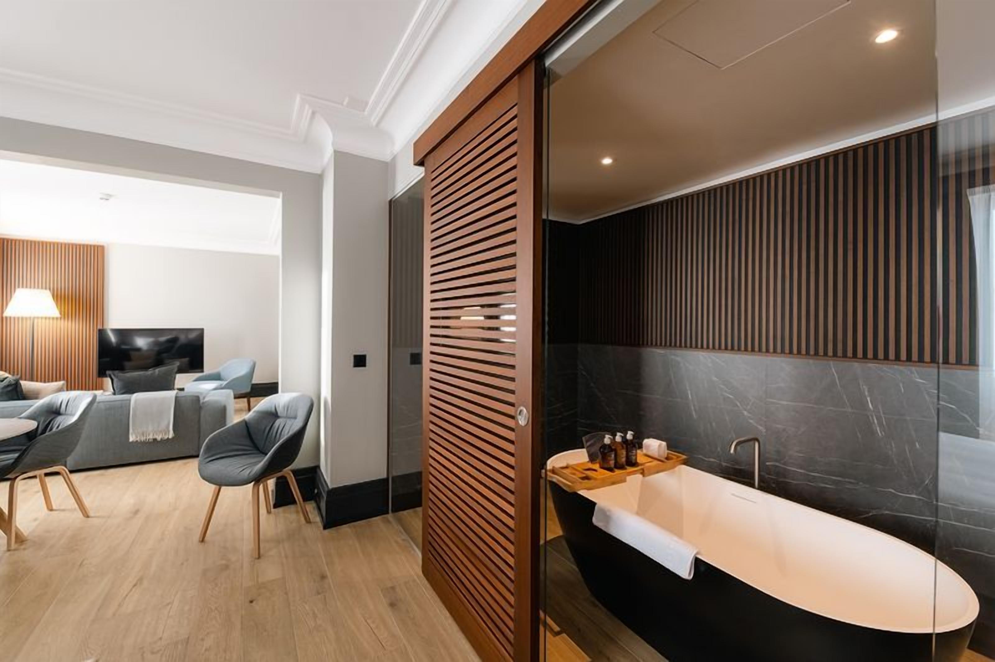 Ein modernes Badezimmer mit einer freistehenden Badewanne, einem Waschtisch mit Spiegel und einer Duschkabine.