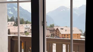 A room with a large window overlooking a mountain landscape.