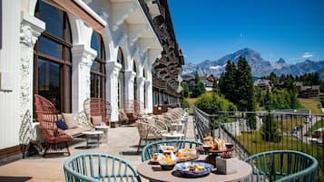 Une terrasse avec des sièges extérieurs et une vue sur la montagne.