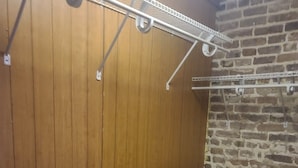 Een kamer met houten lambrisering, een betegelde vloer en een bakstenen muur.