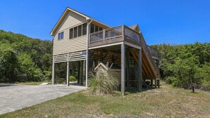 Une maison à deux étages dotée d’un porche abrité et d’une petite terrasse.