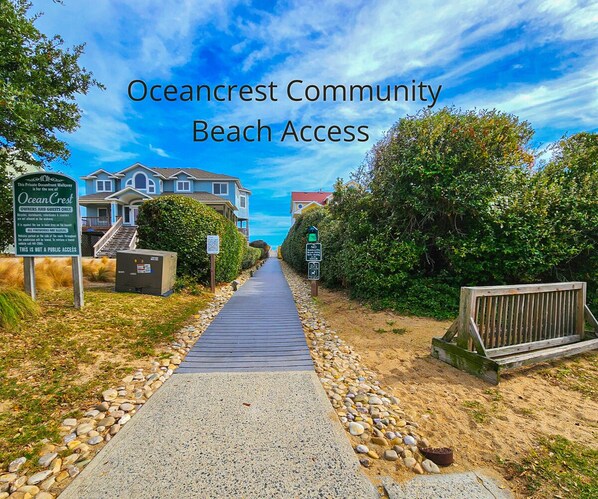 A private oceanfront walkway with a wooden boardwalk, surrounded by houses and dense greenery. - Willows House - Dog-friendly Soundside 2 BR condo w/community pool and sound access (Duck)