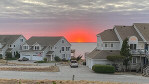 Una hilera de casas de un piso con vista al atardecer sobre el agua.