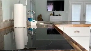 A modern kitchen with a wooden countertop, a black induction cooktop, and a stainless steel sink. - Cozy Clean Coastal Studio... Newly Remodeled! (Corpus Christi)