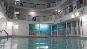 An indoor swimming pool with multiple levels of balconies, clear signage, and a mural of marine life. - Cozy Clean Coastal Studio... Newly Remodeled! (Corpus Christi)