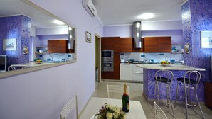 Eine moderne Küche mit Kochinsel, integriertem Backofen und einem Essbereich mit Tisch und Stühlen.