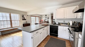 Una cocina moderna con armarios blancos, una isla central y un lavavajillas integrado.