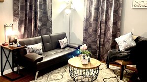 A modern living room with a sofa, a coffee table, and a rug. - Cheerful residential house with all yours needs. (St. Louis)