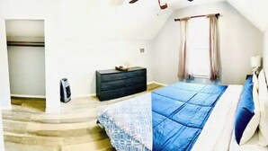 A bedroom with a bed, a dresser, a heater, and a window with curtains. - Cheerful residential house with all yours needs. (St. Louis)