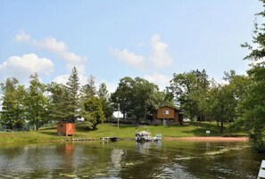 Situated lakeside, this cabin offers a serene escape with a boat docked at its doorstep.