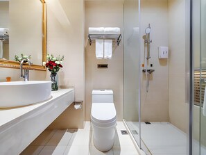 Une salle de bain moderne avec un grand lavabo, des toilettes et une douche à parois de verre.