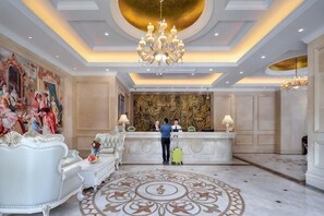 A hotel lobby with a reception desk, ornate chandeliers, and a patterned carpet. - Vienna Hotel (Shanghai Hongmei South Road) (Shanghai)