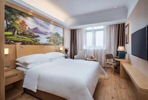 A hotel room with a large bed, a desk, a chair, a TV, and a painting on the wall. - Vienna Hotel (Shanghai Hongmei South Road) (Shanghai)