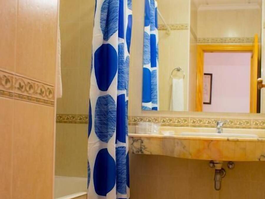 Een badkamer met een bad, een wastafel en een spiegel.