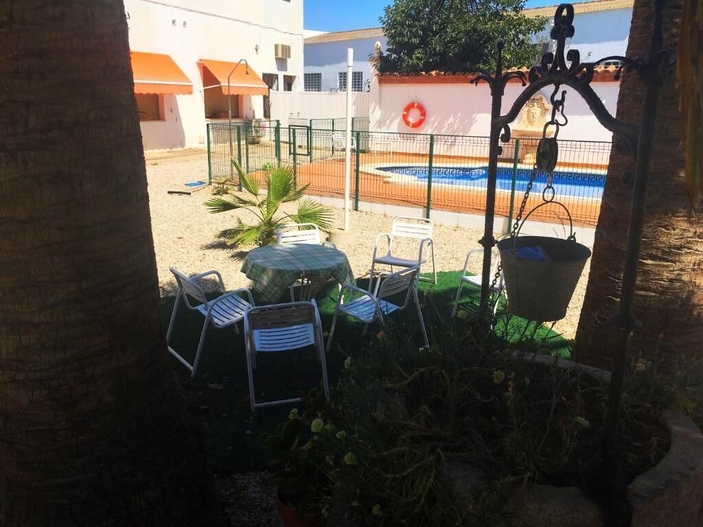 Un área de estar al aire libre con piscina y un flotador en la pared.