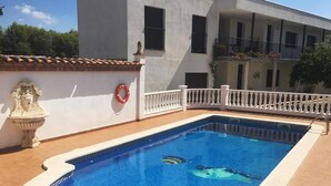 Una piscina rectangular con borde blanco, barandilla blanca y un flotador en la pared.