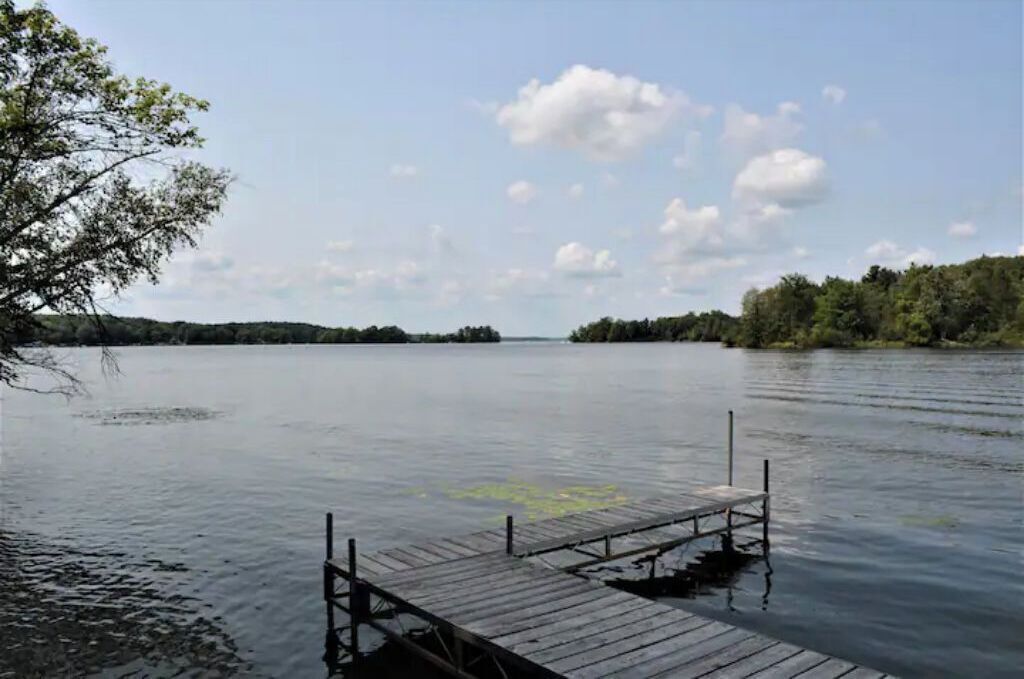 A calm lake with a wooden dock extending into the water.