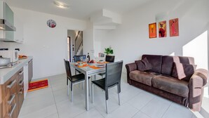 A modern living space with a dining area, a sofa, and a kitchen. - La Perla Di Pianello, Pianello del Lario, Italy (Pianello del Lario)