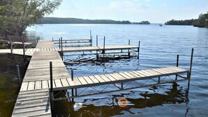 A wooden pier extending into calm water with a clear sky above.