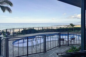 Zona de piscina con vista al océano y a la playa.