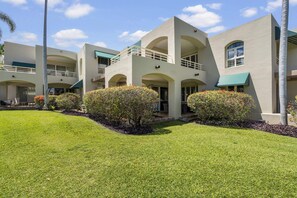 A multi-story hotel with a flat roof, balconies, and a well-maintained lawn with shrubs. - Palms at Wailea 703 - Modern Renovation, Prime Location, Full AC, Close to Pool! (Kihei)