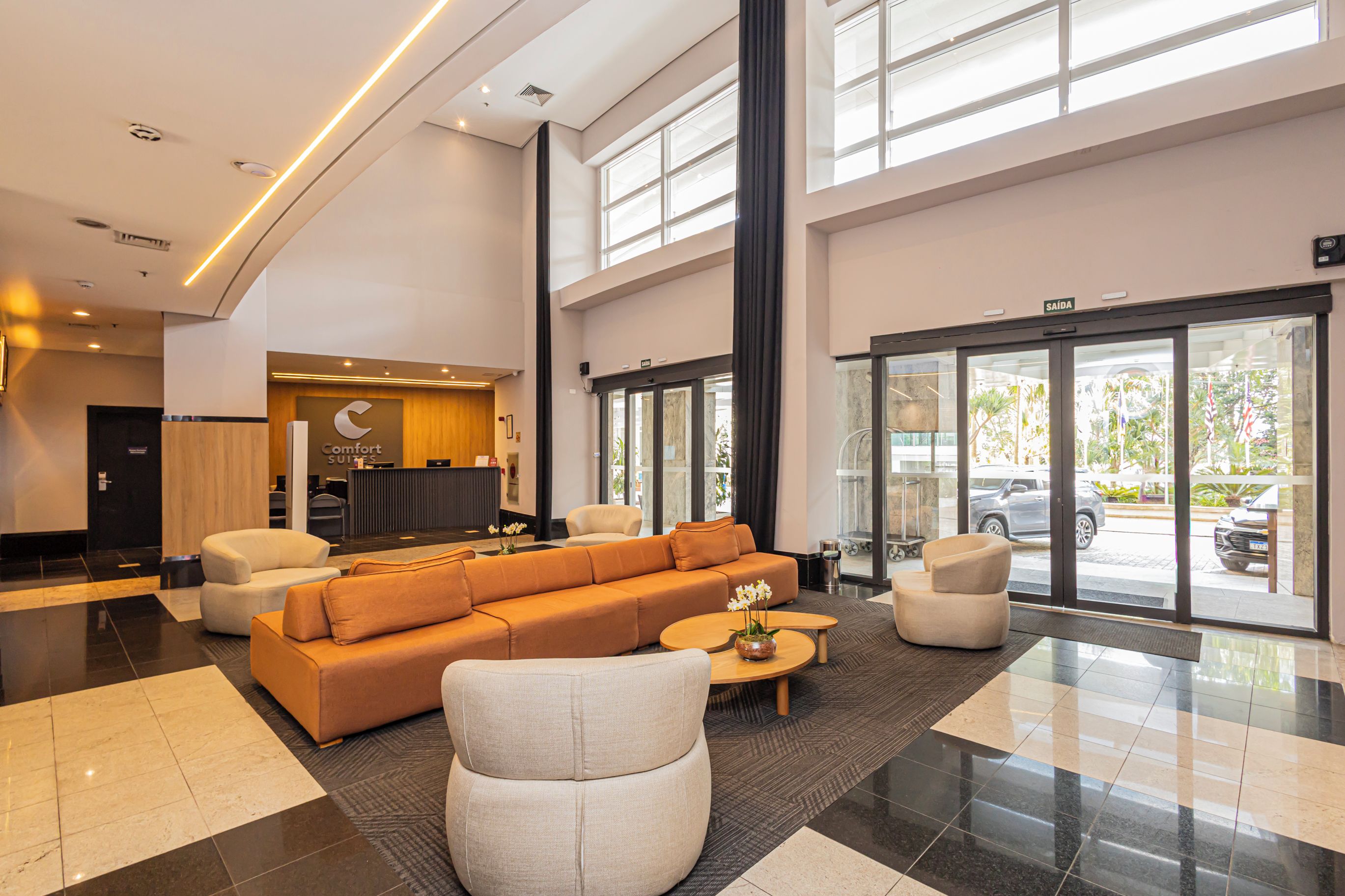 Et hotel lobby med en receptionsdisk, en stor sofa og et sofabord.