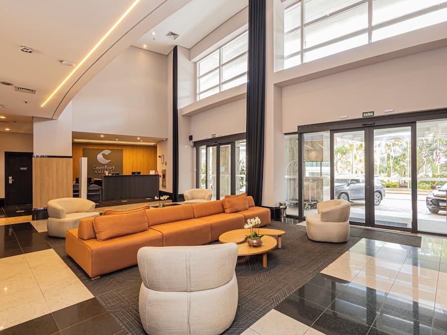 A hotel lobby with a reception desk, a large sofa, and a coffee table.