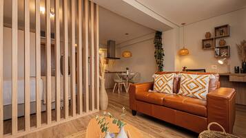 Ein modernes Wohnzimmer mit einer Ledersofa, einer Holzwand und einem Essbereich mit Tisch und Stühlen.