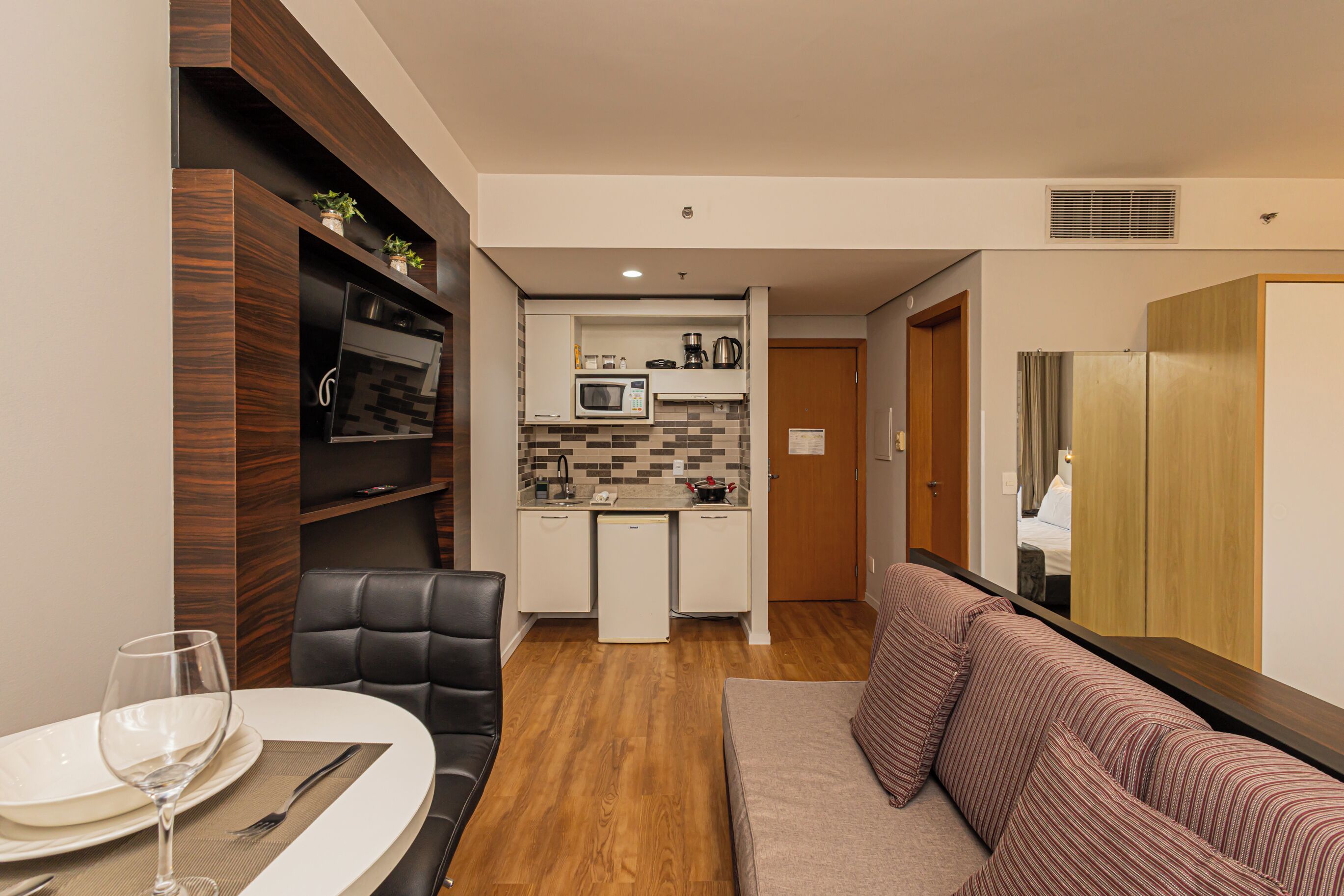 A compact living space with a kitchenette, dining area, and a seating area.